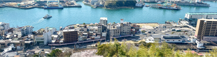 尾道を上から見下ろした風景。海や町並みが広がっている。